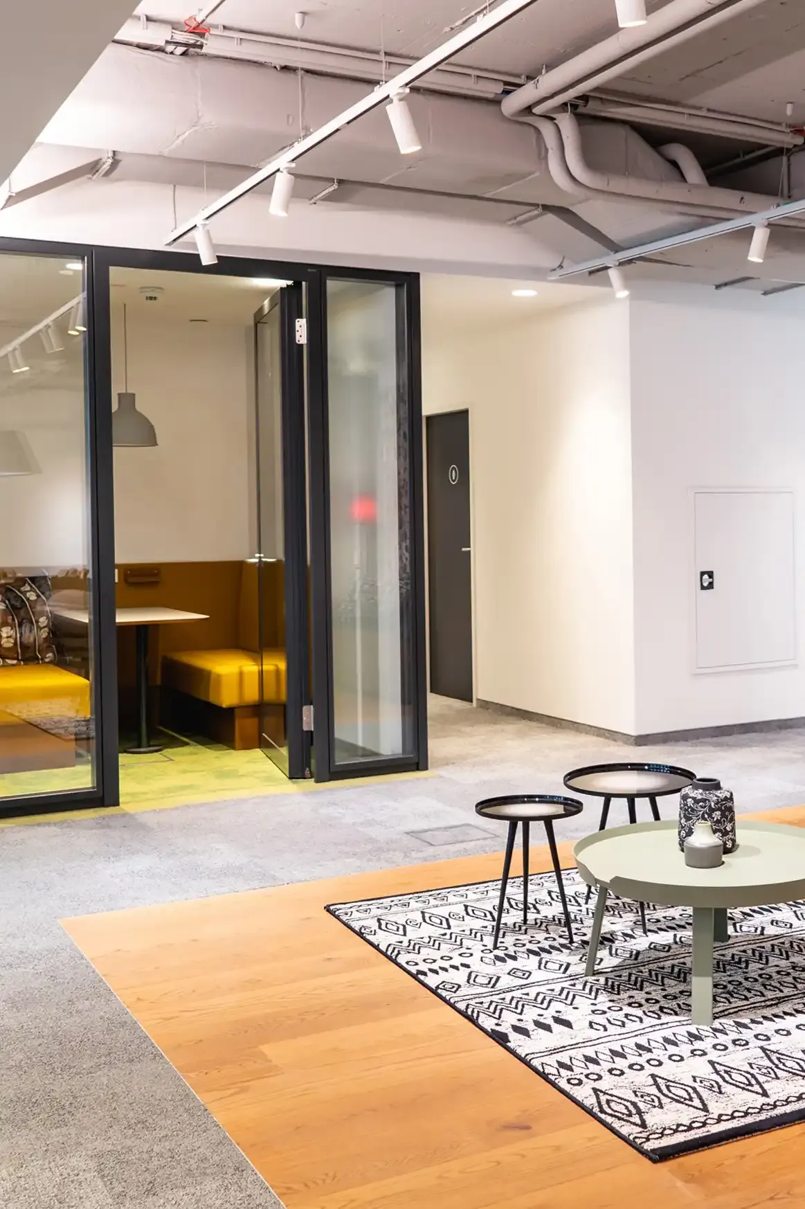 Moderne Bürofläche mit Sitzlounge und Glaswänden – Immobilienfoto einer Gewerbeimmobilie in Wien